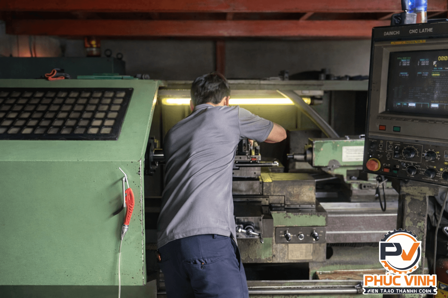 ảnh nhân viên đứng gia công tại máy CNC trong xưởng Phúc Vinh